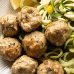 Delicious baked chicken meatballs served with marinara sauce and herbs