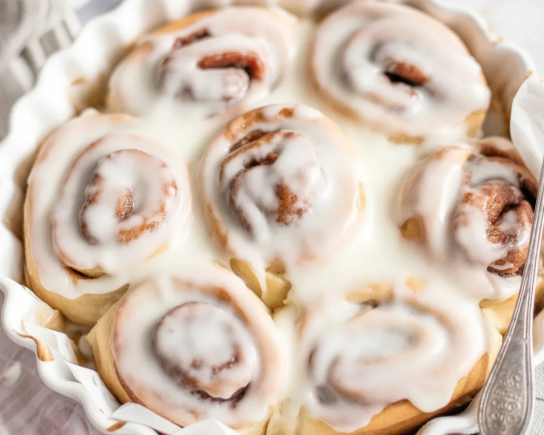 3-ingredient banana cinnamon rolls no yeast topped with icing on a plate.