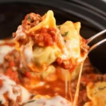 Delicious Crockpot Ravioli Lasagna with layers of cheese and sauce in a slow cooker.