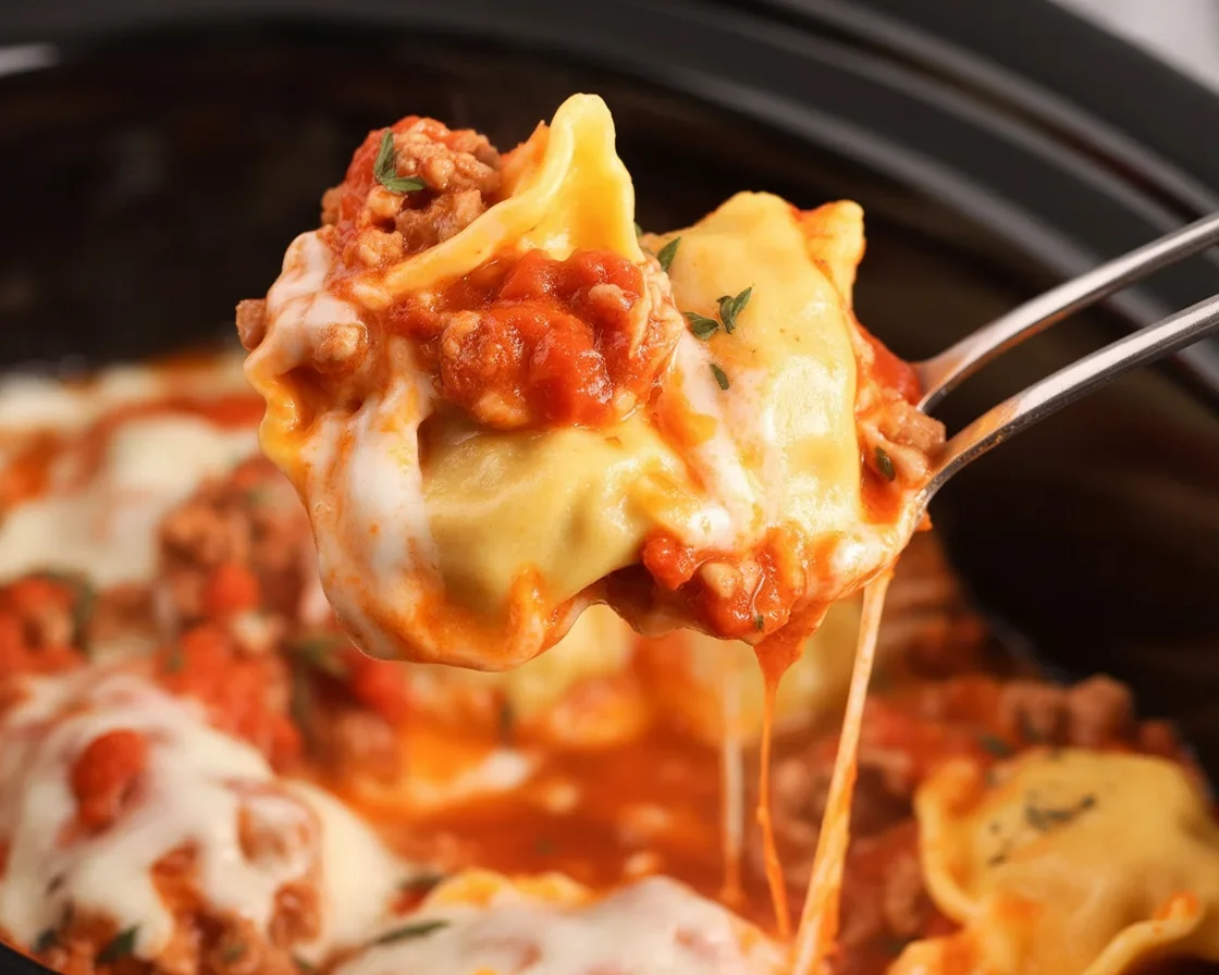 Delicious Crockpot Ravioli Lasagna with layers of cheese and sauce in a slow cooker.