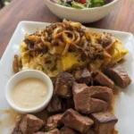 Delicious garlic butter steak bites on a plate garnished with herbs.