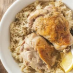 Slow Cooker Lemon Herb Chicken and Rice served in a bowl with fresh herbs.