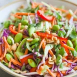 Bowl of Asian Peanut Slaw with colorful shredded cabbage and creamy dressing.