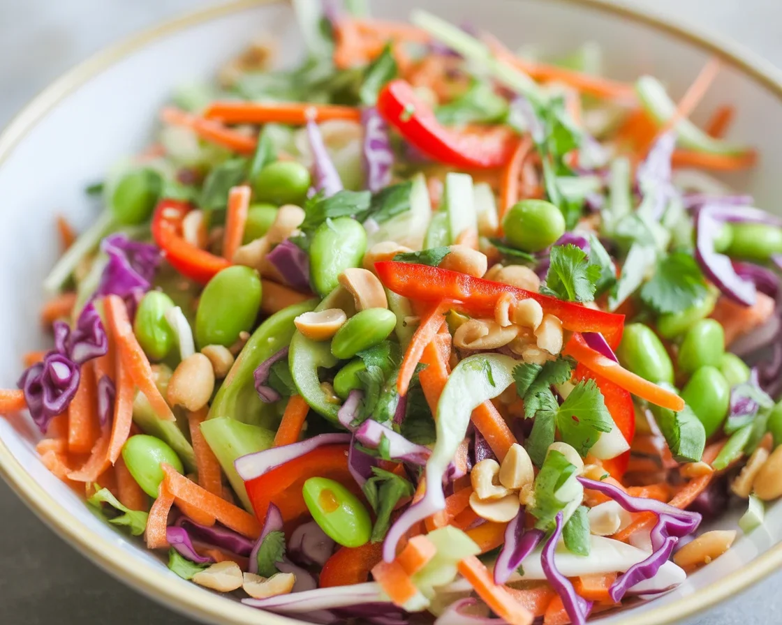 Bowl of Asian Peanut Slaw with colorful shredded cabbage and creamy dressing.