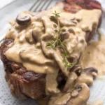 Creamy mushroom gravy served over grilled steak for a delicious BBQ dish.