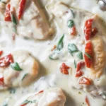 Creamy Parmesan Chicken Breasts with Sun-Dried Tomatoes and Garlic served in a skillet.