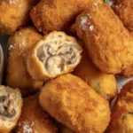 Crispy Potato and Mushroom Croquettes served on a plate, garnished with herbs.