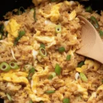 Delicious Hibachi Fried Rice served in a bowl, topped with green onions and healthy ingredients.