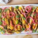 Delicious grilled elote corn with chili lime seasoning, topped with cheese.
