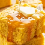 Slice of Honey Butter Sweet Potato Cornbread drizzled with honey and topped with butter.