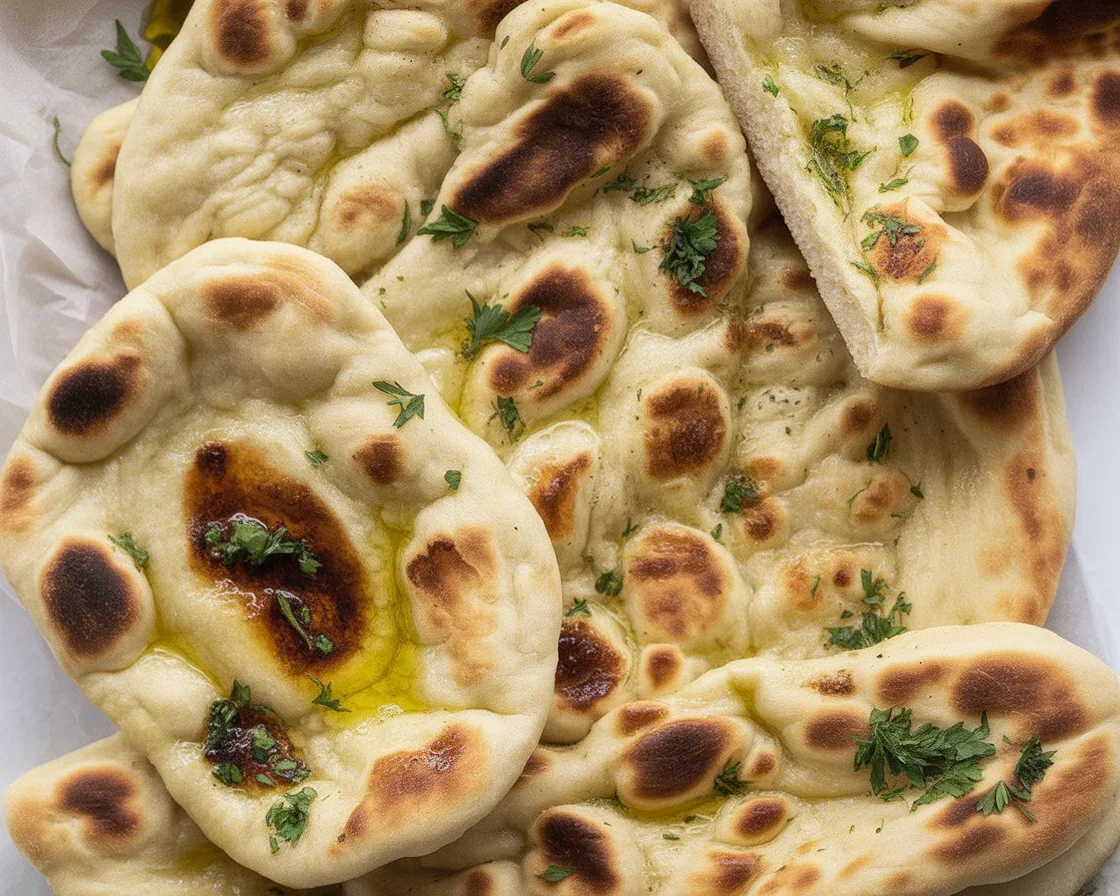 Buttery Garlic Naan Bread brushed with melted garlic herb butter served warm.