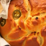 Freshly baked Jalapeno Cheddar Dutch Oven Bread with a crusty exterior and cheesy filling.