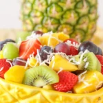 Colorful Tropical Fruit Salad with Honey-Lime Dressing in a bowl.